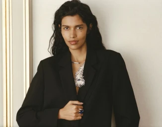 Model Pooja Mor wearing a black blazer and statement diamond necklace against a neutral background