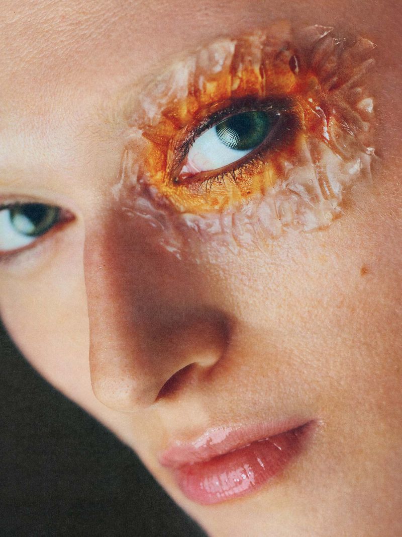 Close-up portrait of a model with textured amber and nacre prosthetic makeup around one green eye for Schön Magazine.