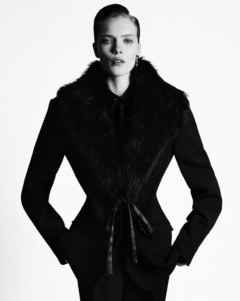 Model Penelope Ternes wearing a structured black jacket with a fur collar against a white background