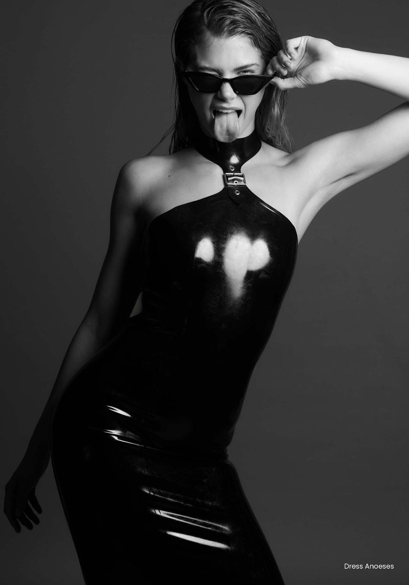Model Abigael Boivin in black latex dress and sunglasses sticking out tongue for Being Abigael editorial by Erez Sabag