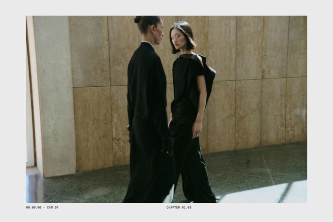 Two models in black clothing standing in a corridor with tiled walls for Massimo Dutti studio campaign