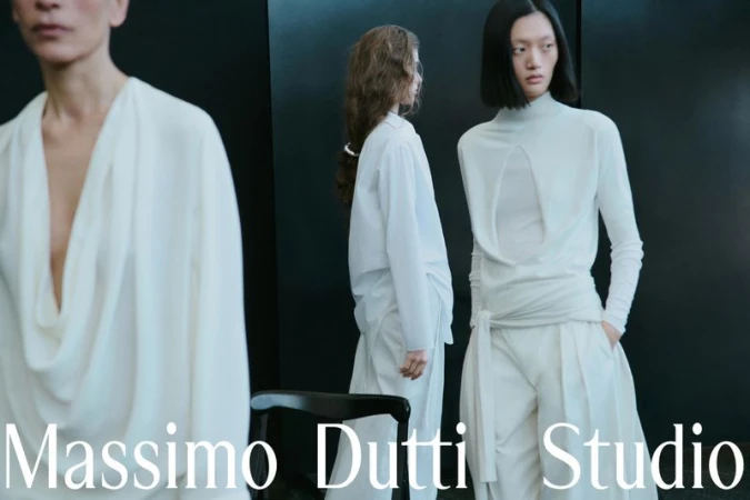Models in white contemporary garments posing against a dark wall for Massimo Dutti Studio campaign
