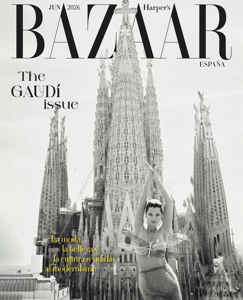 Magazine cover featuring a woman with dragonfly details in front of Sagrada Familia cathedral in Barcelona, Spain, in black and white.