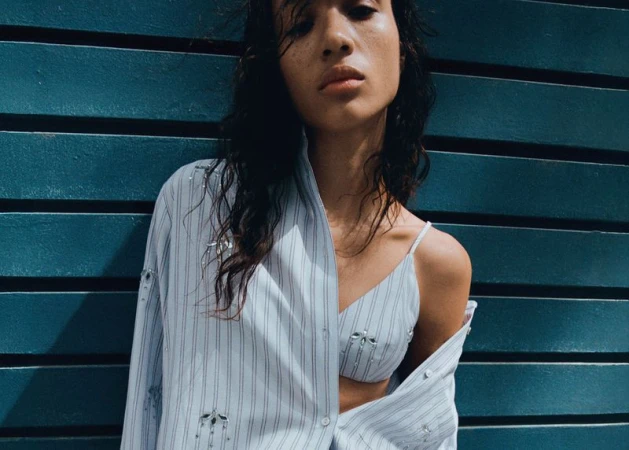 Model Mauria Caetano in a striped shirt and matching top against a teal slatted wall for Mango PJ Craft.