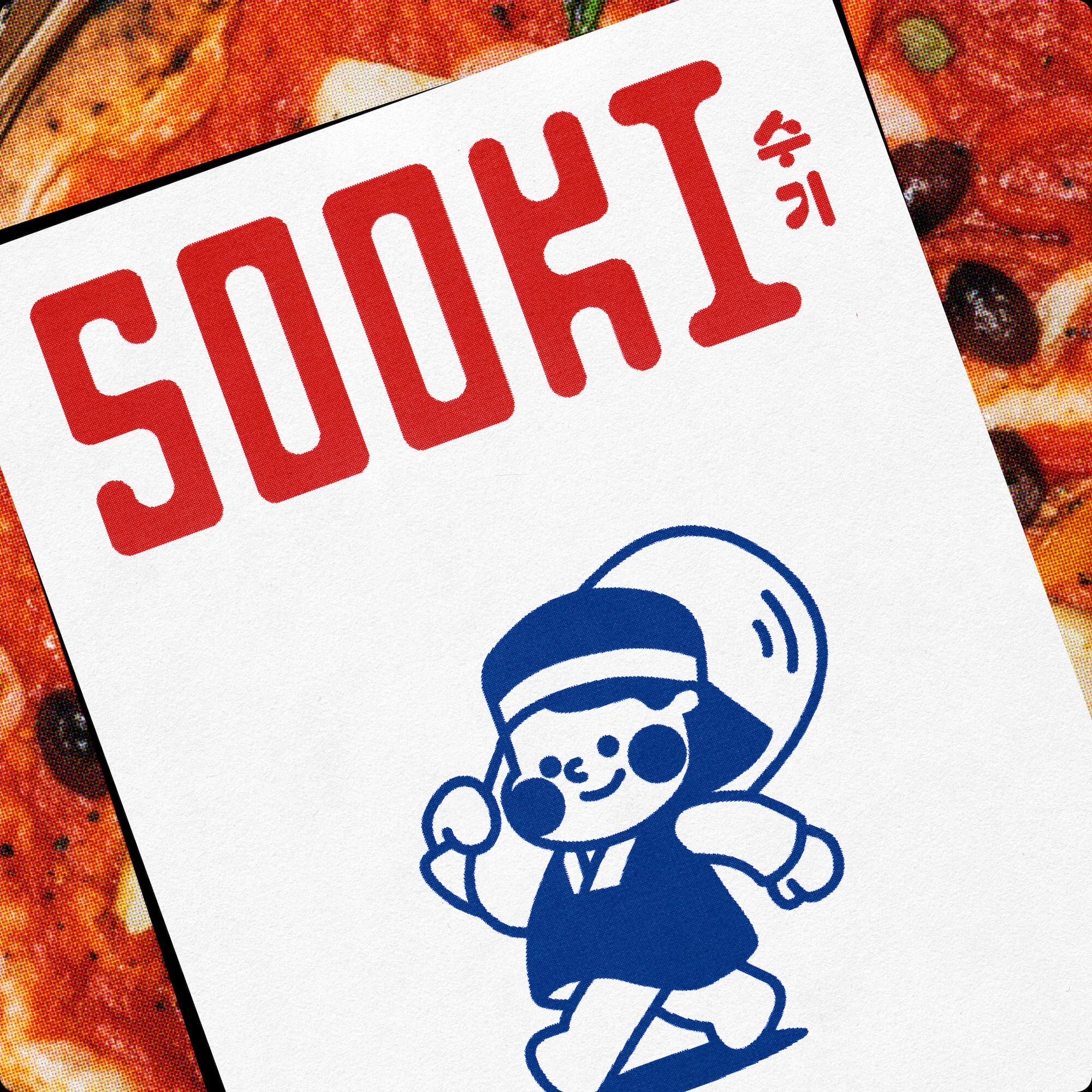 Close-up of a white paper packaging card with red typography spelling SOOKI and a blue line illustration of a running character.