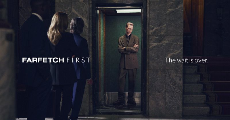 Fashion-forward scene in a marble lobby with a man in a suit inside an elevator, as people wait, promoting luxury brand FARFETCH FIRST.