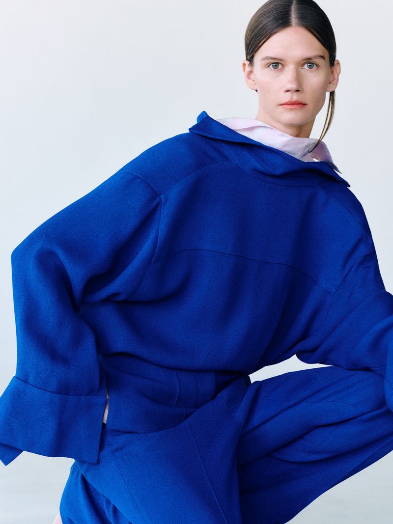 Model wearing a vibrant blue top and matching trousers posing against a clean white backdrop for Tove
