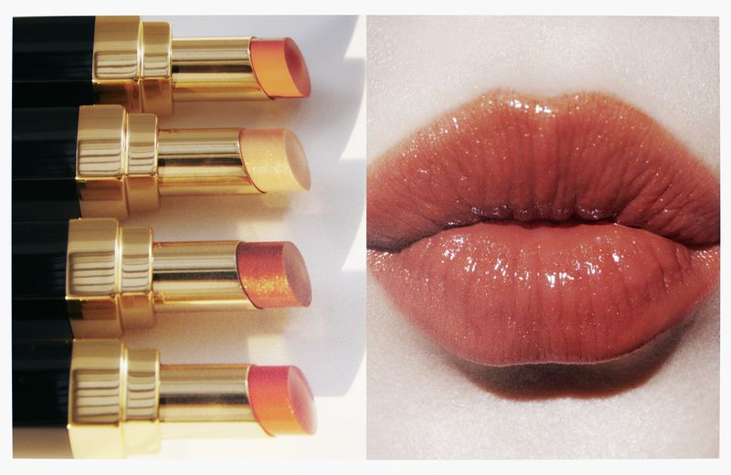 Beauty shot featuring four lipstick tubes with exposed product alongside a close-up of a woman's glossy, coral-toned lips.