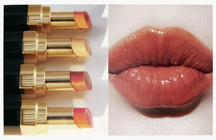 Beauty shot featuring four lipstick tubes with exposed product alongside a close-up of a woman's glossy, coral-toned lips.