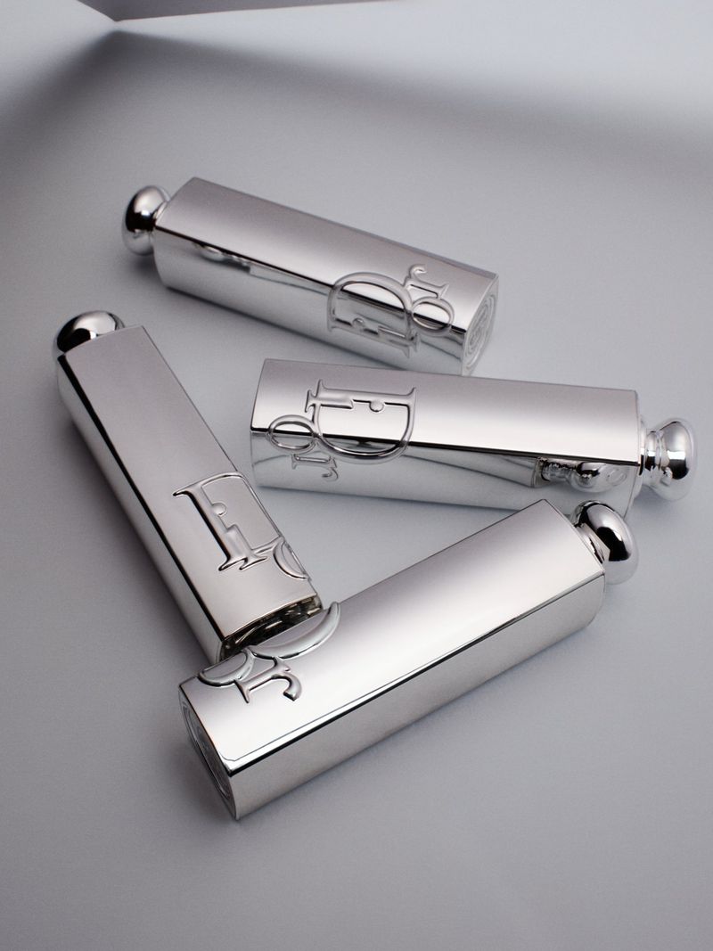 Four silver metallic lipstick tubes arranged diagonally against a plain light grey studio backdrop.
