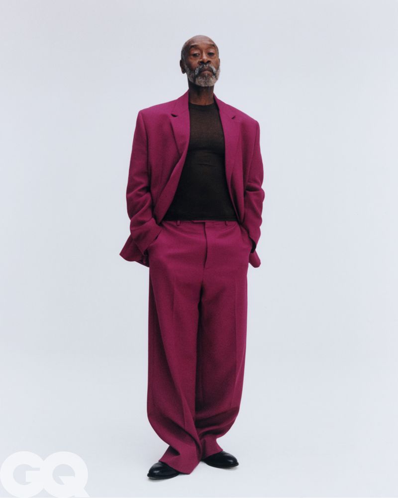 Don Cheadle wearing a plum suit and black shirt against a plain white background for GQ Magazine