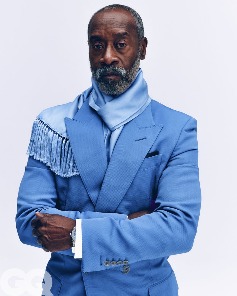 Portrait of Don Cheadle wearing a blue suit jacket and matching scarf against a white background
