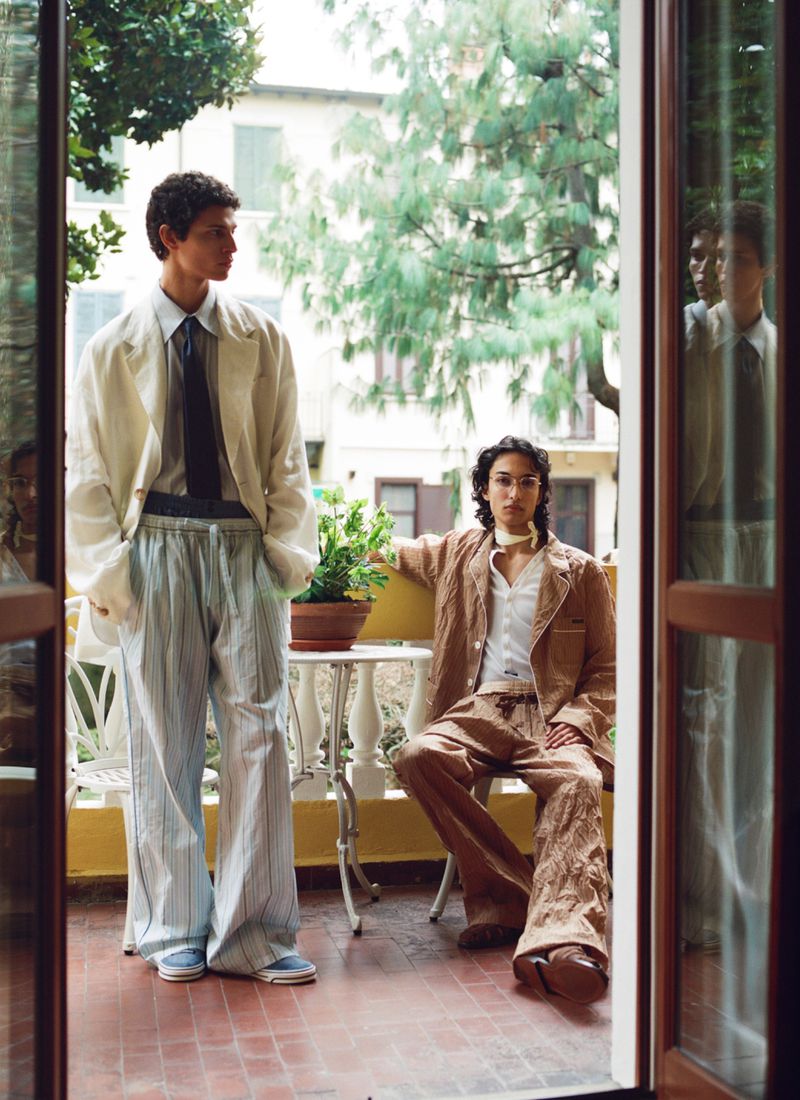 Two male models posing on a balcony viewed through open French doors for ICON Magazine Mena.