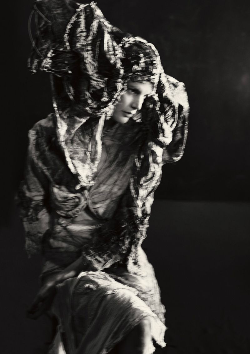 Model Saskia de Brauw in textured dark garments and elaborate headdress for Luncheon Magazine photographed by Paolo Roversi.