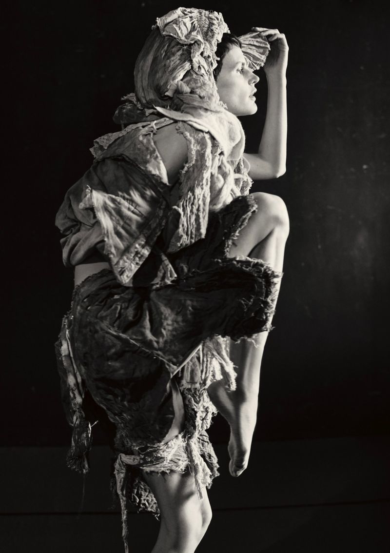 Model Saskia de Brauw in layered distressed garments and head covering posing against a dark background for Luncheon Magazine