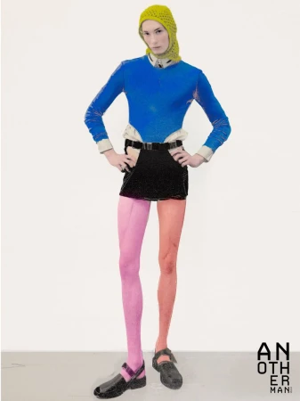 Model wearing a blue top, black skirt, and yellow head covering standing against a white backdrop for AnOther Man China.