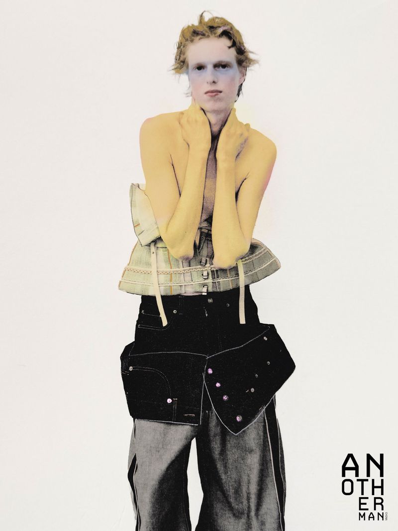 Model wearing a structured corset top and dark baggy trousers against a plain white background for AnOther Man China.