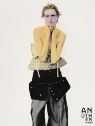 Model wearing a structured corset top and dark baggy trousers against a plain white background for AnOther Man China.