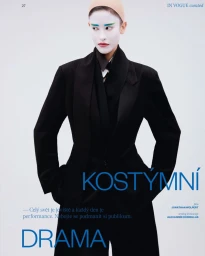 Model in black blazer and trousers with white painted face makeup against a pale background for Vogue Czechoslovakia