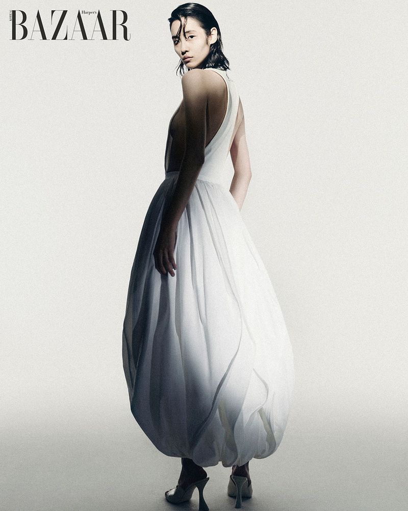 Model wearing a white dress with a voluminous skirt against a neutral background for Harper's Bazaar Korea