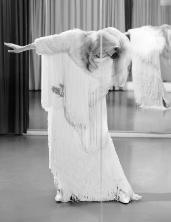 Model Birte Carolin Von Knoblauch wearing a white fringed gown posing in a mirror reflection