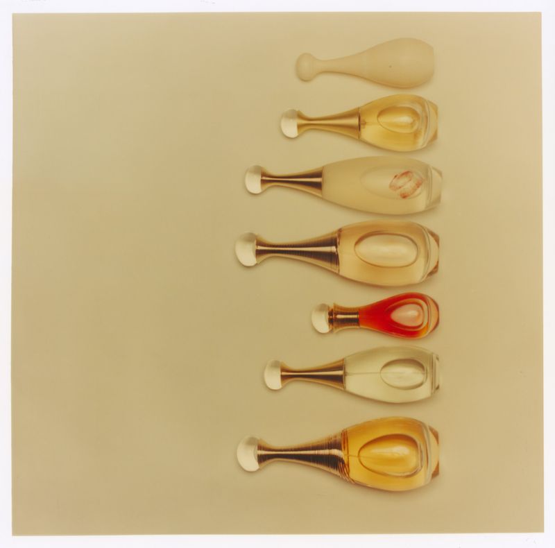 Seven perfume bottles aligned vertically on a solid beige background