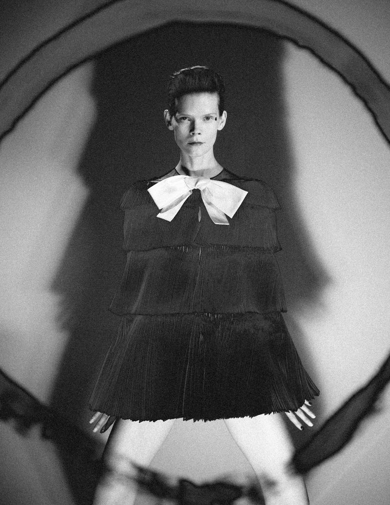 Model Irina Kravchenko in a tiered dark dress with a white bow for L'Officiel Italia photographed by Frederico Martins