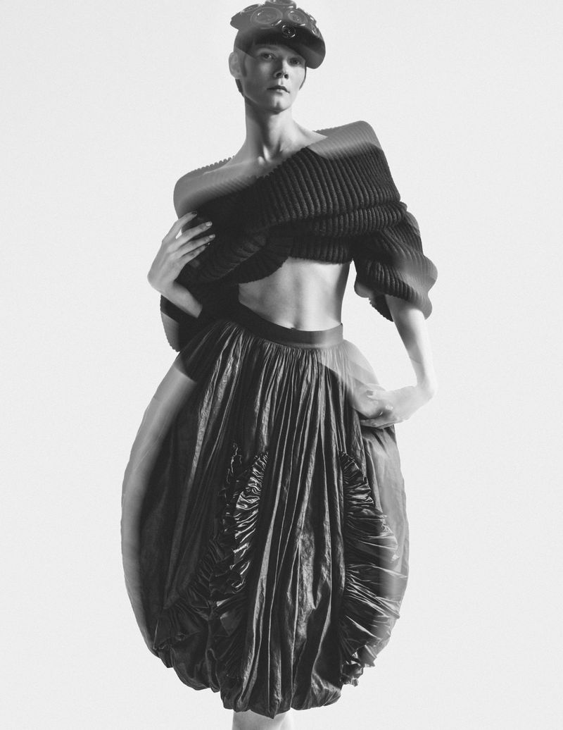 Model Irina Kravchenko wearing a pleated black top and balloon skirt with a cap for L'Officiel Italia