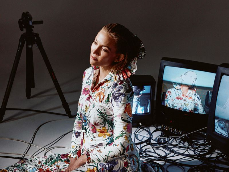 Kate Hudson wearing floral print jumpsuit sitting amid CRT monitors and tangled cables for L'Officiel Italia editorial