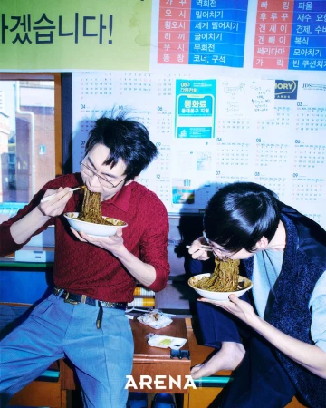 Two men eating noodles with chopsticks indoors with calendar posters on the wall for Arena Homme Plus Korea by Less Kim Tae Kyun