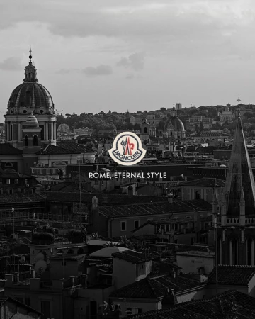 Monochrome rooftop view of Rome cityscape with domes and spires under an overcast sky featuring a central Moncler brand logo.