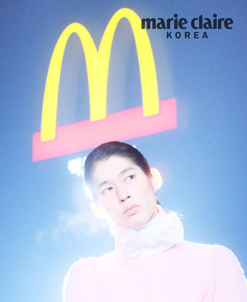 Model in pink sweater wearing a white neck scarf standing beneath a glowing yellow Mcdonald's sign for Marie Claire Korea