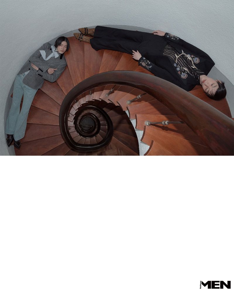 Two models lying on wooden steps of a spiral staircase shot from high above in an editorial project for Noblesse Korea.