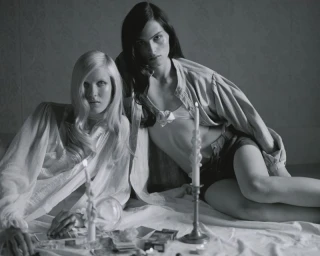 Black and white editorial portrait of two female models posing with candles and cards for Vogue Ukraine by Antonino Cafiero.