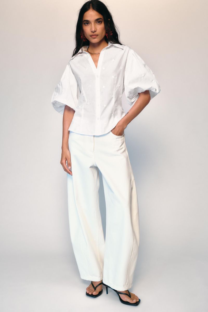 Model wearing a white puff-sleeve shirt and wide trousers against a white seamless background for Zara Vacation Mood