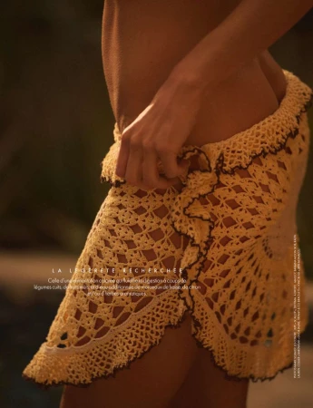 Woman wearing a crocheted sarong, showcasing fashion and textiles with warm lighting and blurred background, creating a soft, summery aesthetic.