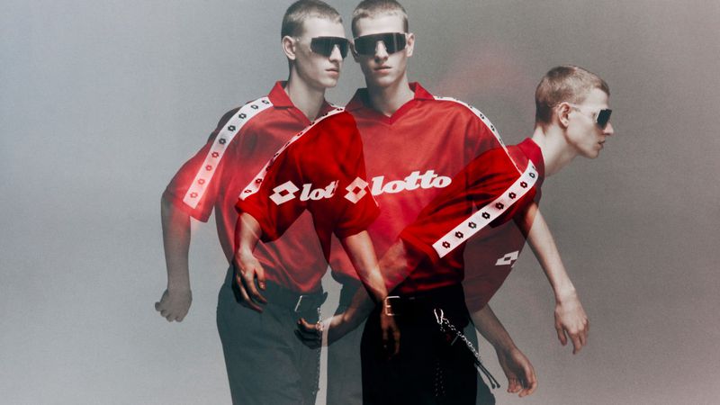 Multiple exposure fashion image of a male model wearing a red Lotto jersey and sunglasses against a grey backdrop.