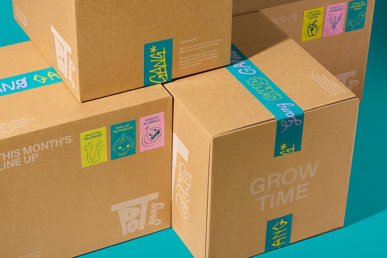 Cardboard delivery boxes with printed branding and colourful tape labels stacked against a bright teal background.