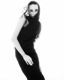 Model wearing a black dress and sheer veil against a white background for Vogue Portugal
