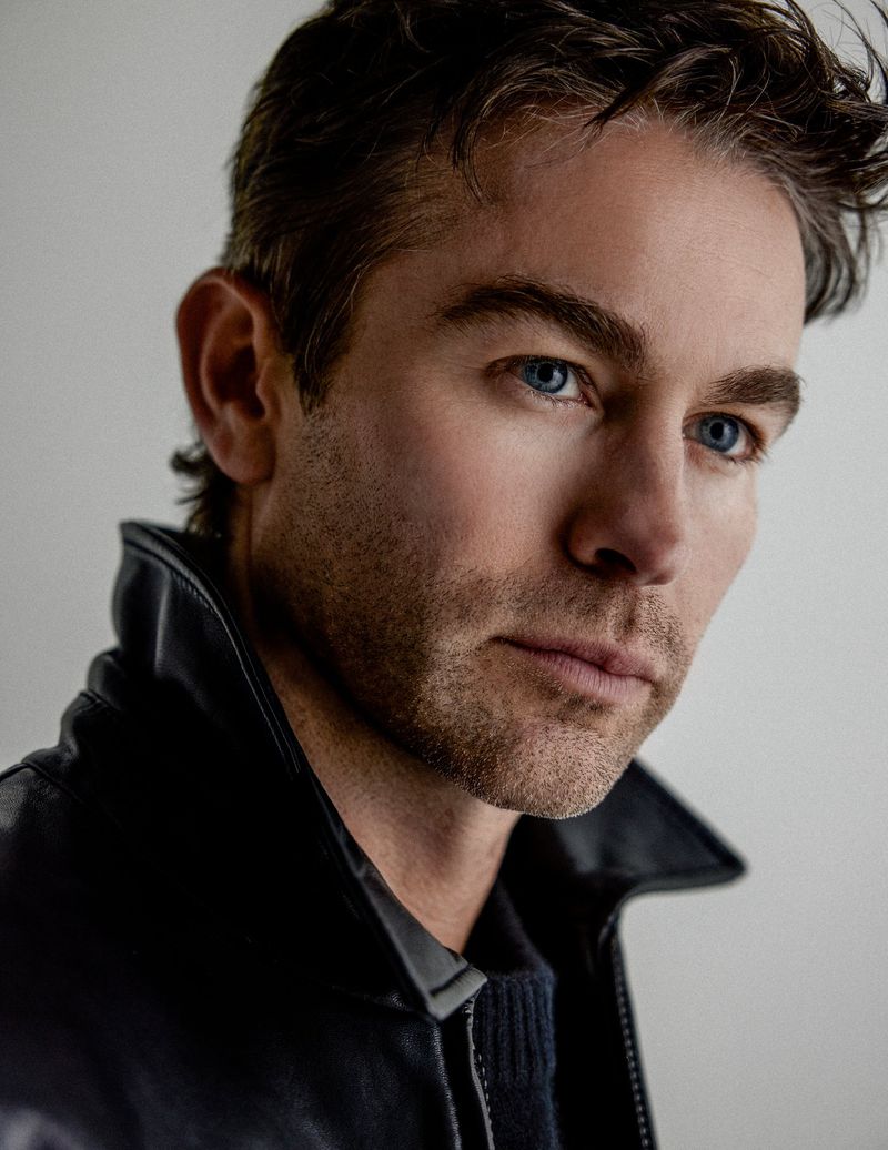 Close-up portrait of actor Chace Crawford wearing a black leather jacket against a neutral grey studio background.