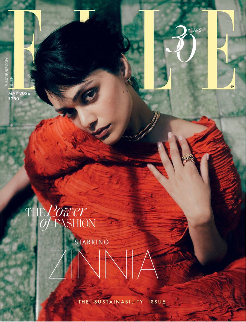 Model Zinnia Kumar in a textured red dress on a stone surface for Elle India May 2026 cover photographed by Noemi Ottilia Szabo.