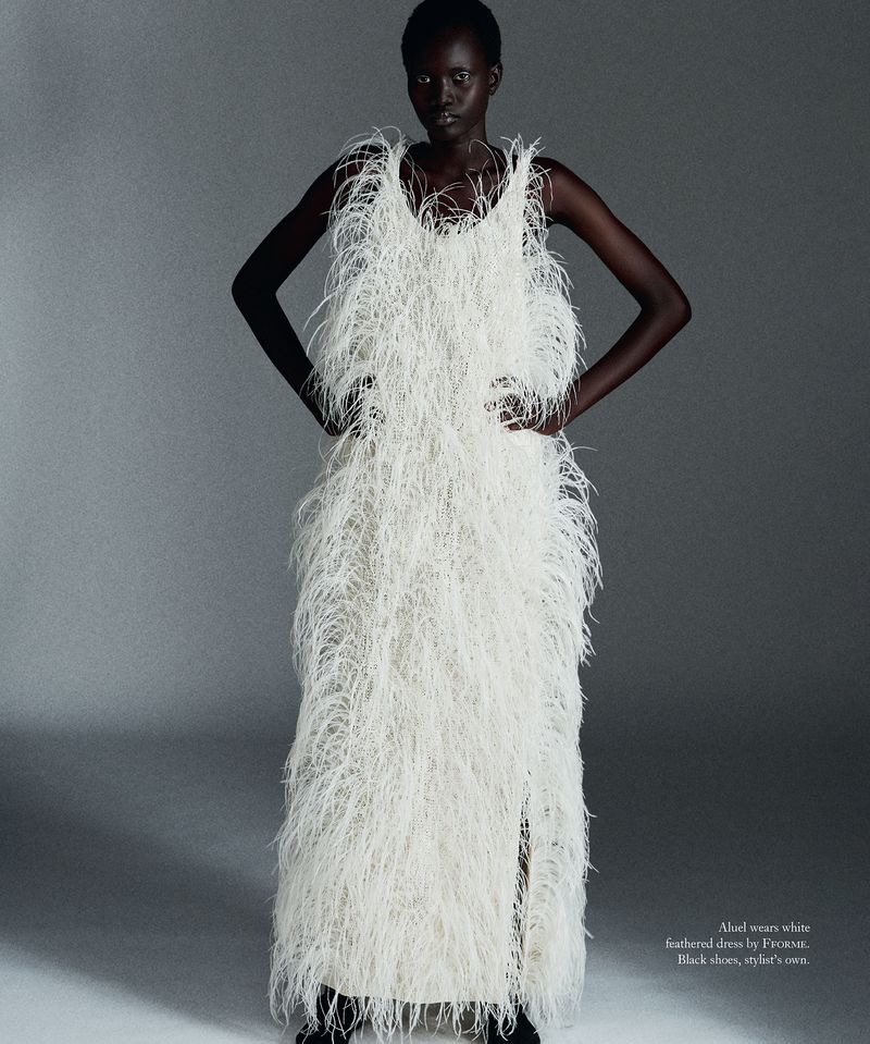 Model Aluel Keror wearing a white feather dress against a grey studio backdrop for Mission Magazine.