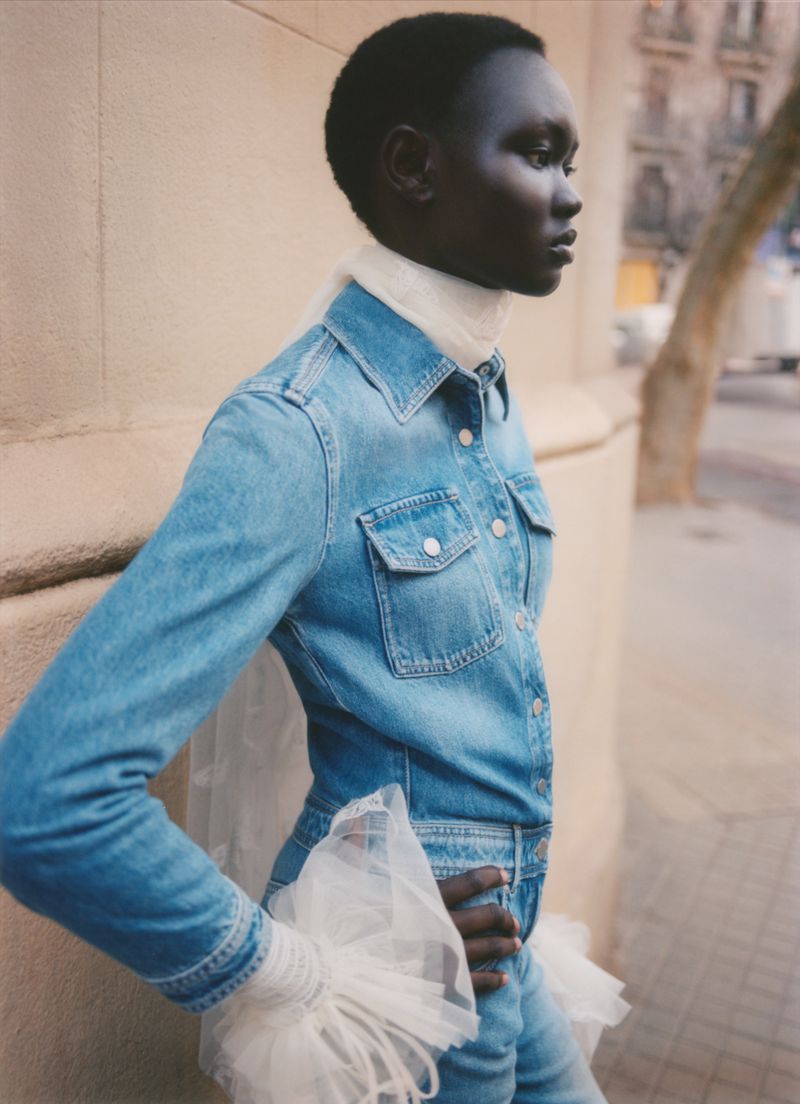 Model Ateta Jok wearing a blue denim shirt and jeans with white tulle cuffs for Vogue Polska photographed by Pía Riverola.
