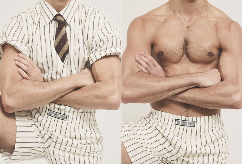 Two male models standing side by side against a white background, one wearing a striped shirt and shorts with a tie