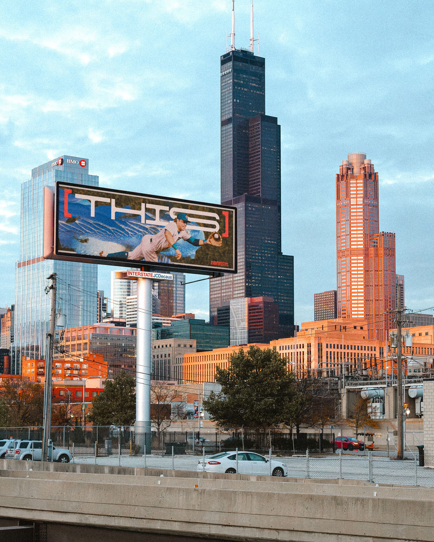 Outdoor billboard showing a Chicago Cubs advertisement with the Sears Tower and Chicago skyline in the background.