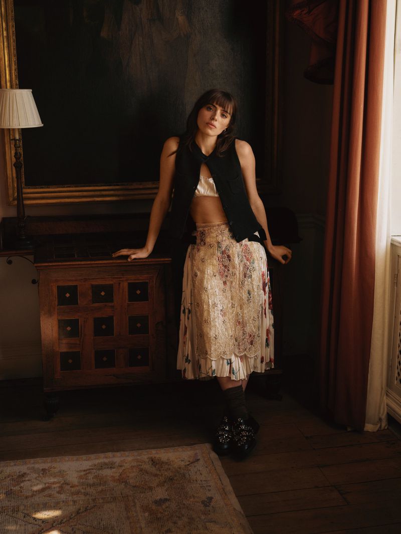 Bella Maclean leaning against a wooden cabinet in a traditional room for Telegraph Luxury editorial photography.