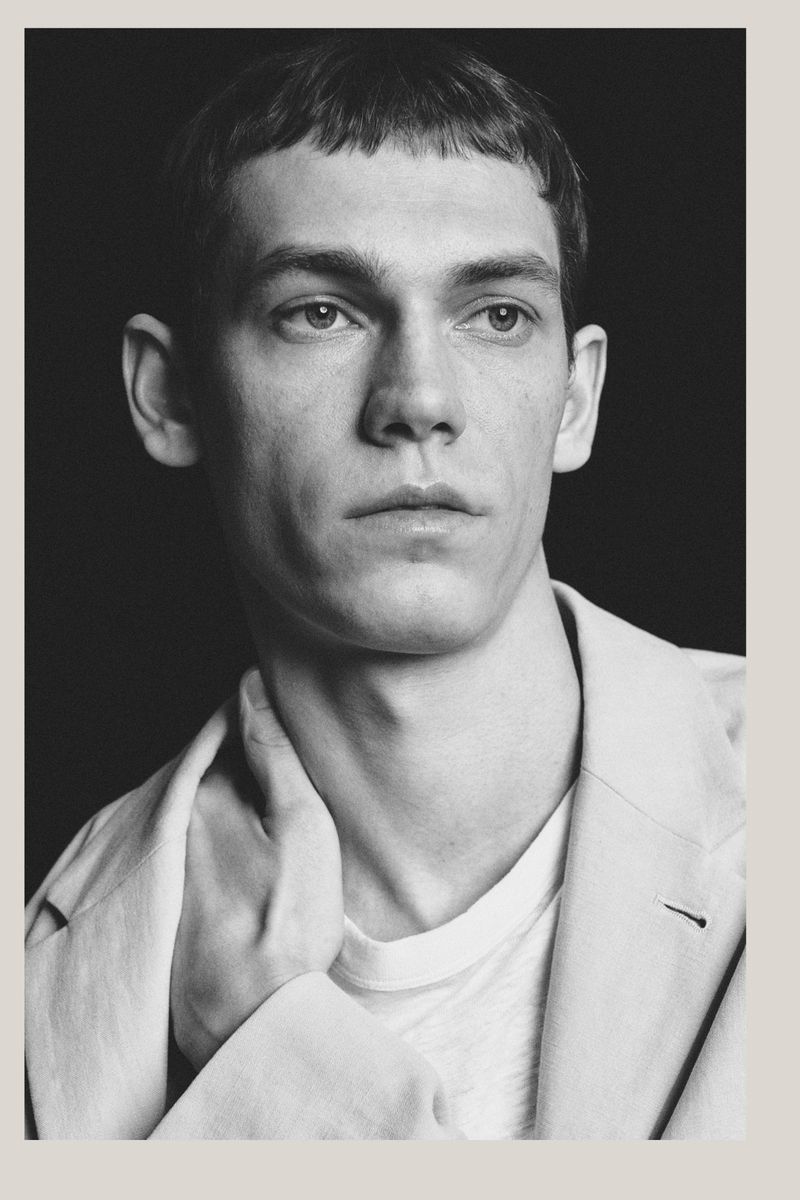Portrait of a male model wearing a light blazer and white t-shirt against a dark background for Massimo Dutti Limited Edition S/S 26
