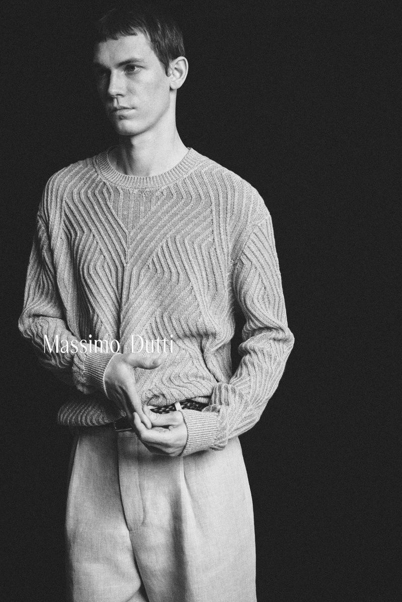 Aleksandr Gordeev wearing a textured knit sweater and tailored trousers against a black studio background for Massimo Dutti.
