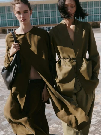 Models Liset Mitjan and Yilan Hua wearing tailored olive green garments outdoors for Massimo Dutti Studio Spring 2026.