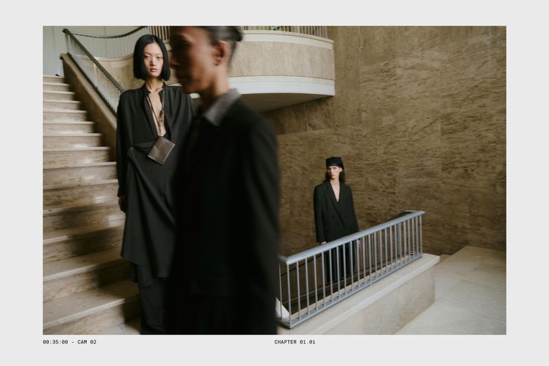 Three models wearing tailored black garments on a grand stone staircase for Massimo Dutti Studio Spring 2026.